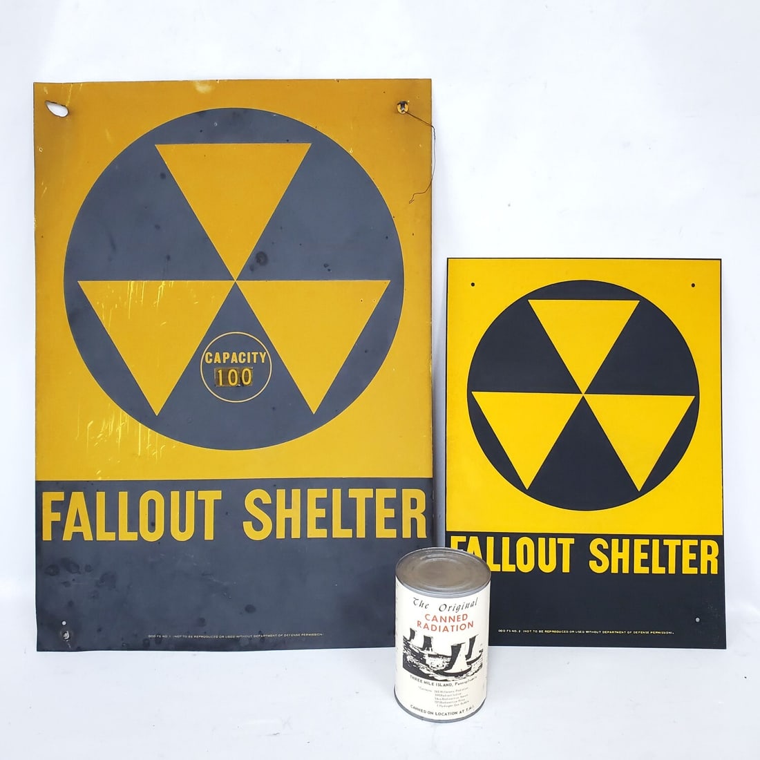 2 Fallout Shelter Metal Signs: 2 Fallout Shelter Metal Signs Along w/ an Original "Canned Radiation". Condition: Generally Good. As Found. Dimensions: Larger-20" x 14". Provenance: From a Long Island, NY Home. Please note the absen