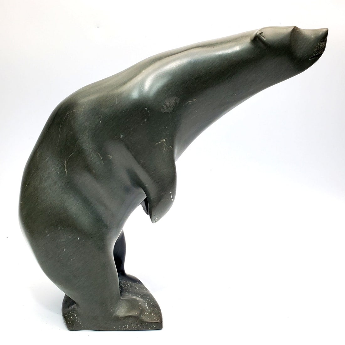 Large Inuit Art Carved Green Soapstone Figure: Large Inuit Art Carved Green Soapstone Figure of a Polar Bear. Signed & Dated '84 On The Bottom. Condition: Generally Good w/ Some Scratches Due to Age. Dimensions: H-11" x L-11". Provenance: From a L
