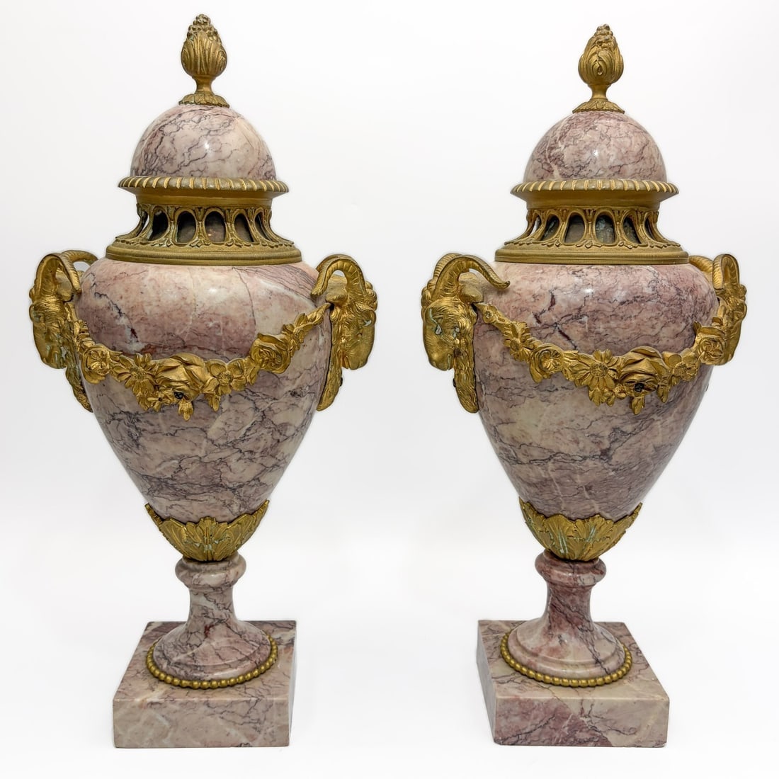 Pair of Antique French Marble & Dore Bronze Urns: Pair of Antique French Louis XVI Style Breche Violette Marble & Dore Bronze Covered Urns w/ Decorations of Ram Heads & Floral Garland. Condition: Generally Very Good. Dimensions: H-16". Provenance: Fr