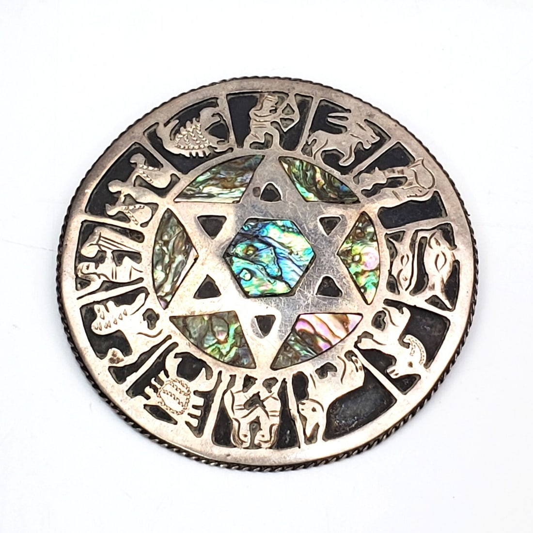 Mexican Sterling Silver Large Brooch: Mexican Sterling Silver Large Brooch w/ Zodiac Signs, Star of David, & Inlaid Shell. Fully Marked. Condition: Generally Very Good. Dimensions: Dia-2.3" Gross Weight: 0.6ozt. / 18.7g. Provenance: From 