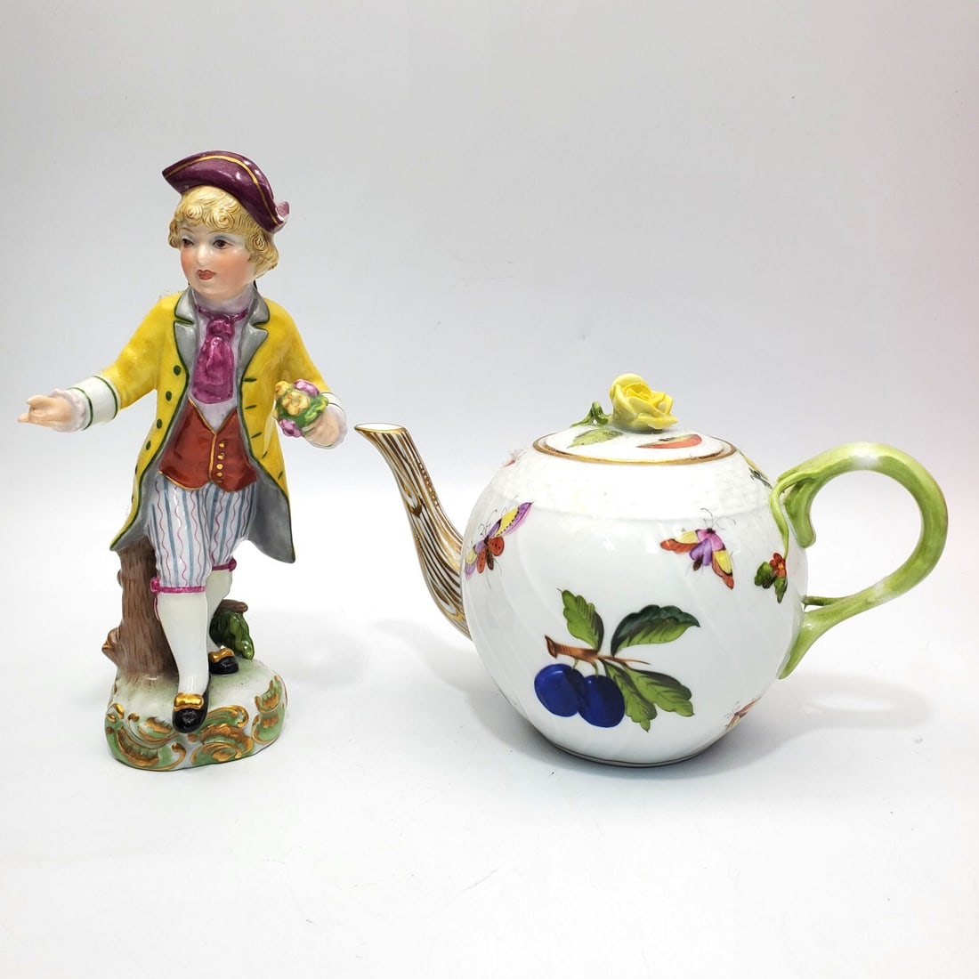 Lot of 2 Herend German Porcelain: Lot of 2 Herend German Porcelain Items Including a "Market Garden" Teapot & a Figure of a Boy w/ Flowers. Both Are Fully Marked. Condition: Generally Good. The Boys Hat Has Some Chips. Dimensions: Tal