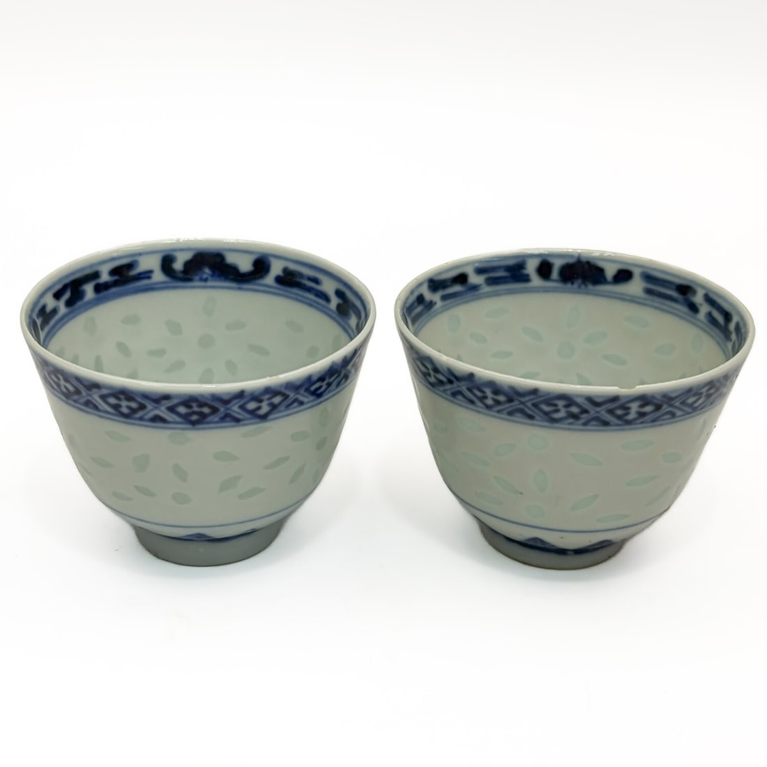 Pair Chinese Signed Blue & White Porcelain Cups: Pair of Chinese Signed Blue & White "Rice Grain" Porcelain Tea Cups. Signed on The Bottom. Condition: 1 Has a Chip on the Rim. The Other is Generally Good. Dimensions: H-2.1" x Dia-2.8". Provenance: F