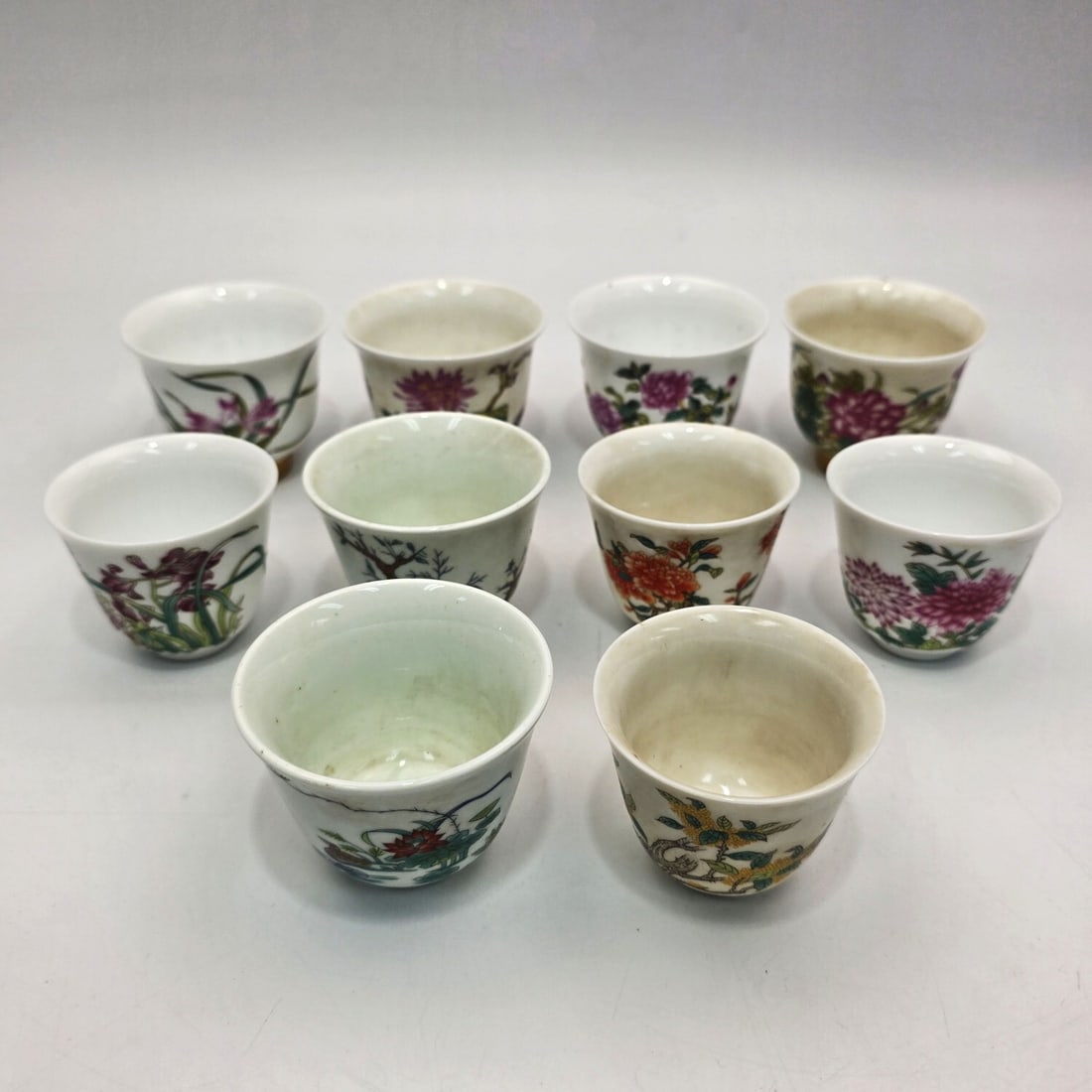 10 Chinese Signed Porcelain Teacups: 10 Chinese Signed Porcelain Teacups w/ Floral Decorations. Condition: Generally Good. Dimensions: Largest-H-2.25" x Dia-2.5". Provenance: From a Long Island, NY Home. Please note the absence of a Cond