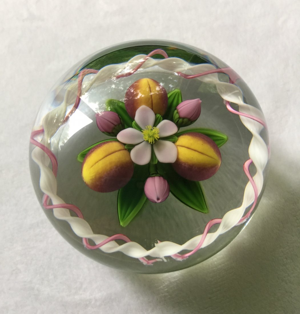 Gordon Smith and Jim Kontes Collaborative Glass Paperwe: Circa 1994, with three peaches interspersed by three pink buds centering a pink blossom with a pink and white ribbon swirl border, with yellow S and K signature canes, numbered 13/20, diameter 2-7/8 i