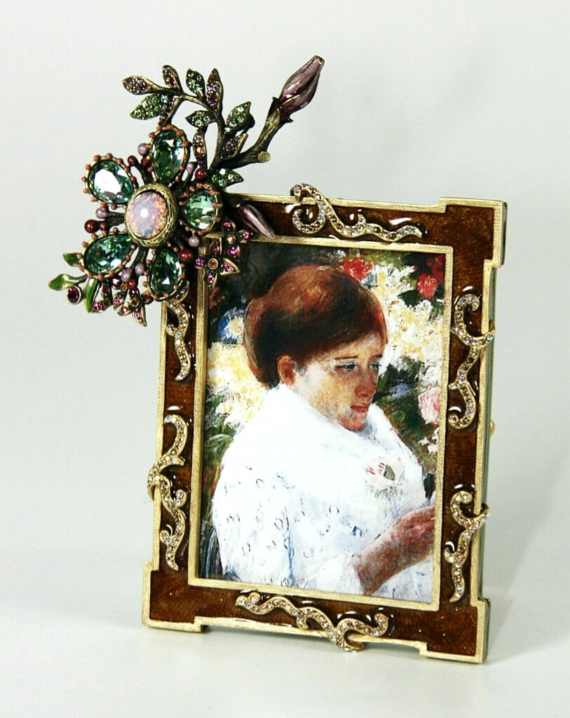 JAY STRONGWATER BLOSSOMING FRAME & DETACHABLE GREEN BROOCH BRONZE SWAROVSKI: Jay StrongwaterBLOSSOMING FRAMEWith DETACHABLE BROOCHFrom CANARY DIAMOND CollectionColor: BRONZE & GOLDHand enameled; hand-set crystals.Holds an 2" x 3" photograph.Frame: 5"T x 4"W (Frame Only)BROOCH: