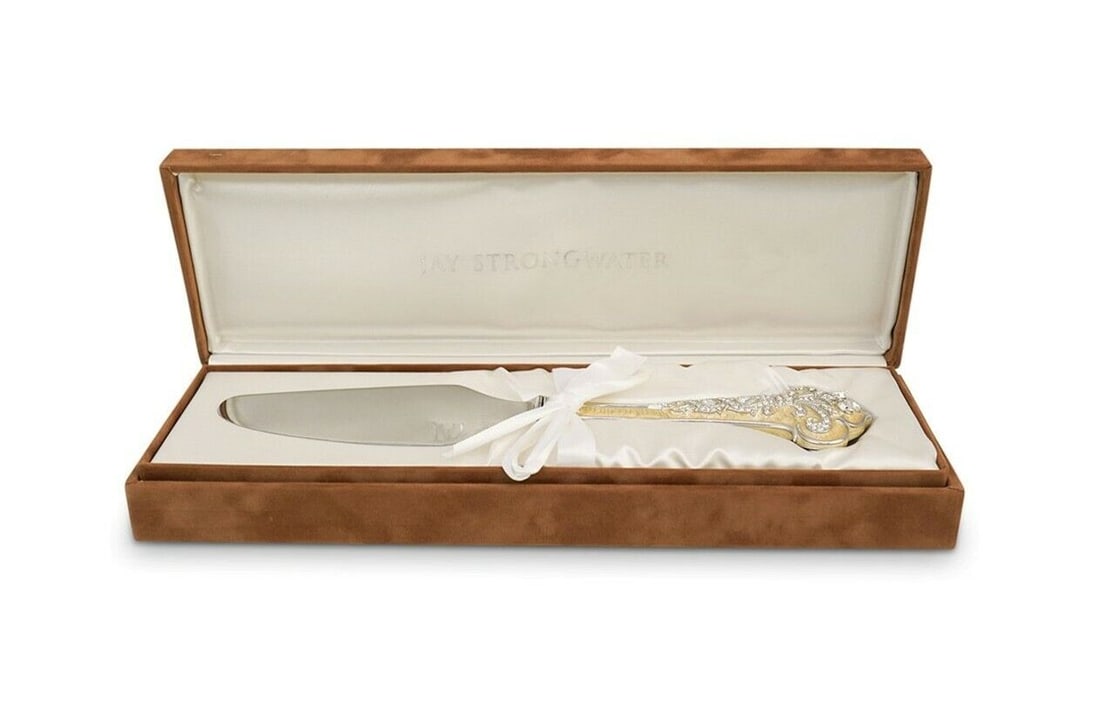 Jay Strongwater "Vivienne Duchess" Cake Knife: JAY STRONGWATERFrom the Duchess Collection.Handle, white hand-painted enamel over metal in fleur-de-lis design; Hand-set clear Swarovski® crystals. Silver-tone trim.Blade, engraved with "Jay Strongwa