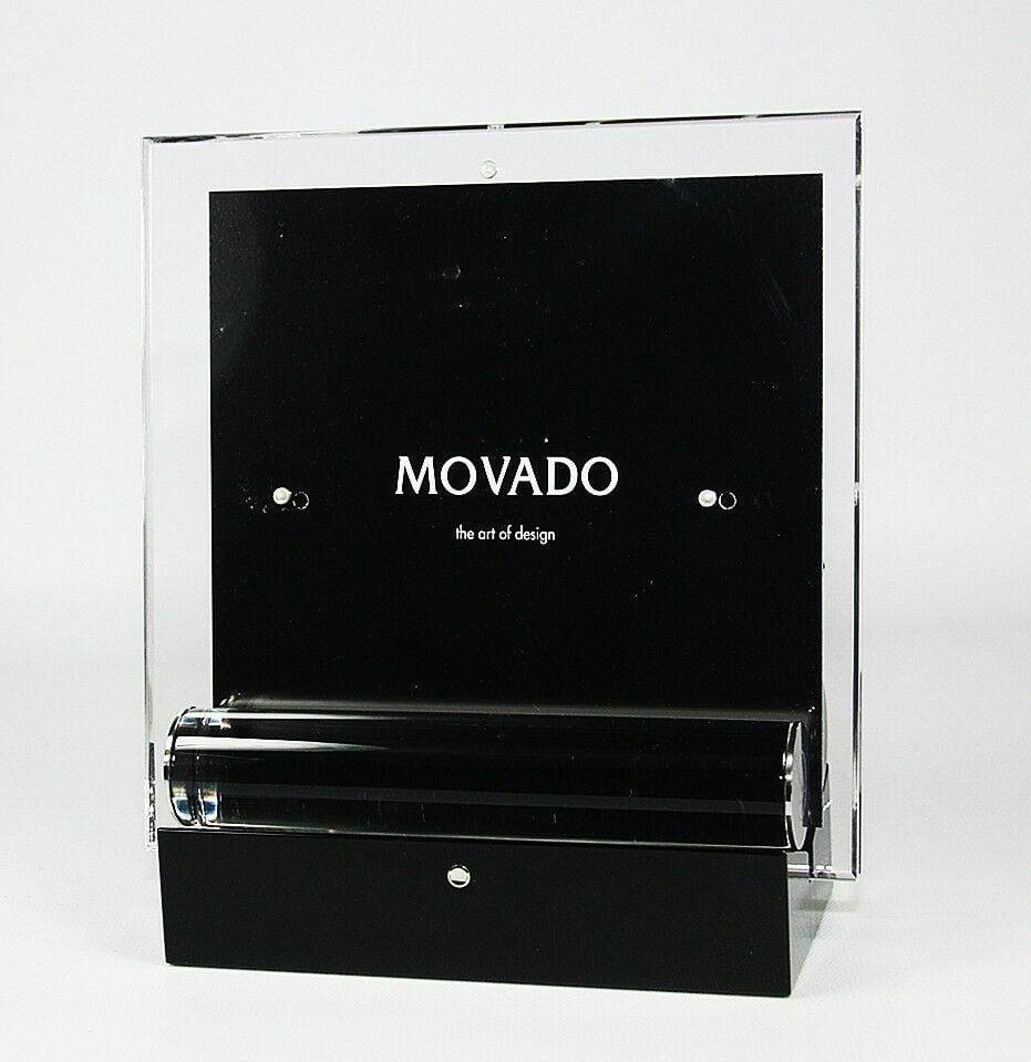 MOVADO MUSEUM DOUBLE SIDED PHOTO & PICTURE FRAME: MOVADOMUSEUM PHOTO FRAMEBRAND NEW IN ORIGINAL MOVADO BLACK BOXWith ORIGINAL Foam InsertsOn Heavy Black Piano Finish StandWith MOVADO Emblem on Front PanelAnd on Glass HoldersMODEL: DBK000213M7 1/2" Hi