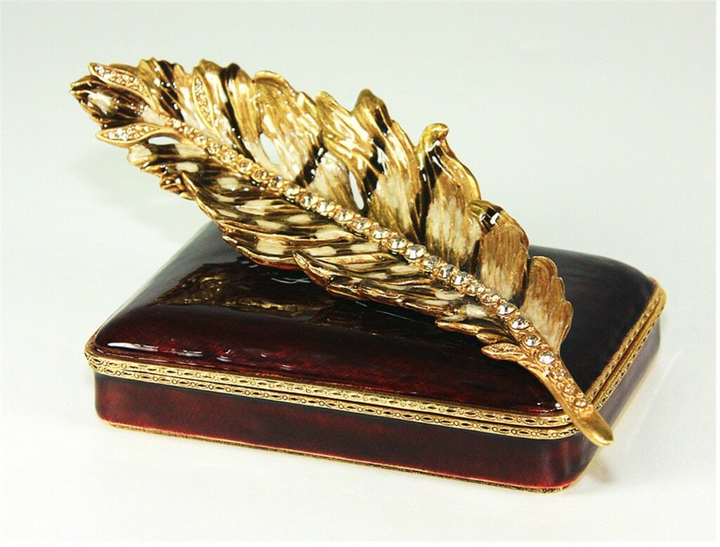 JAY STRONGWATER KYLE PLUME TRINKET BOX SWAROVSKI NEW $995: JAY STRONGWATERMADE IN USA!Three-dimensional pheasant featherRests atop a box of deep claretHand-set with Swarovski crystalsHandpainted enamel over metal5.75" Wide x 2.75" Deep x 4" TallBRAND NEW, ORI