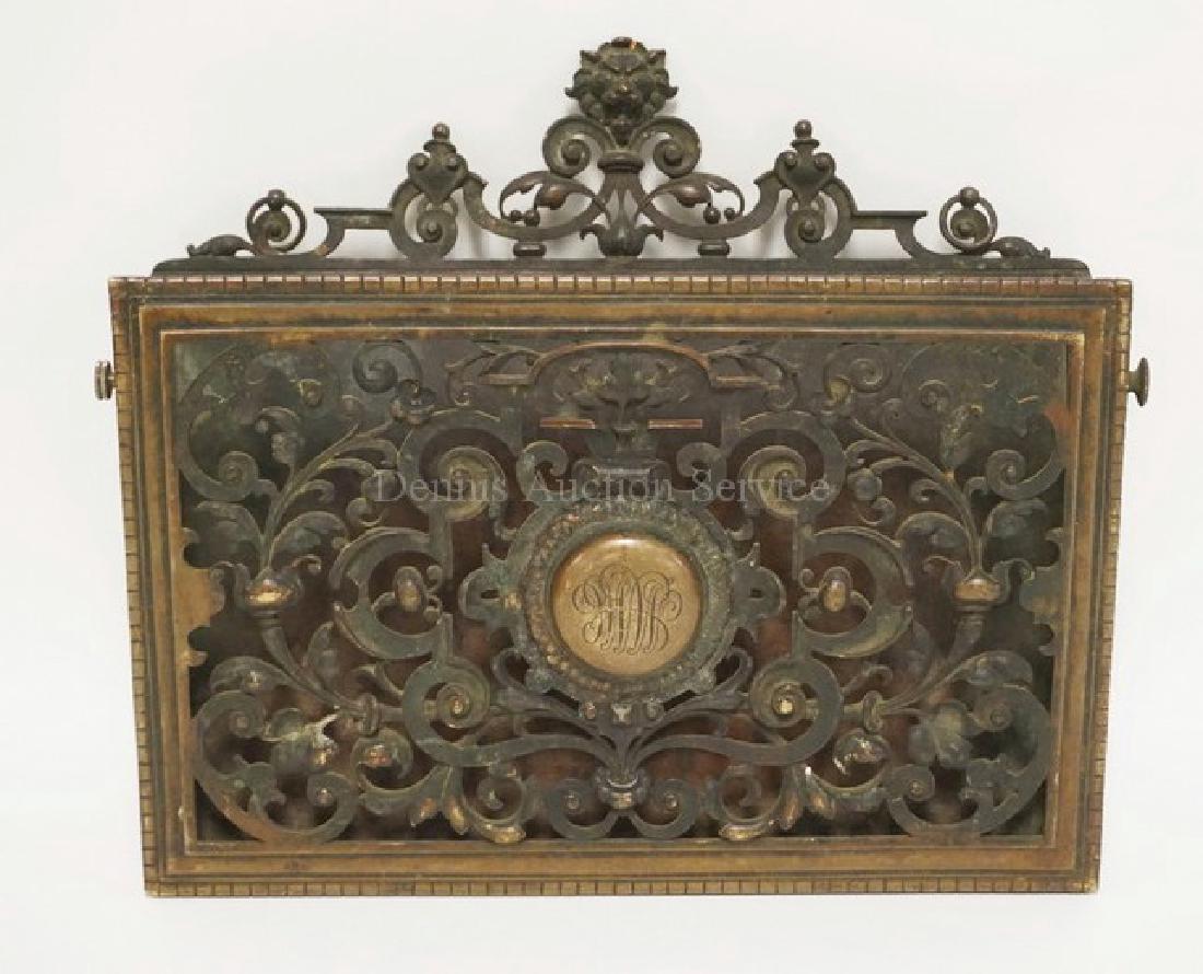 ANTIQUE BRONZE LETTER HOLDER WITH AN OPENWORK DESIGN.: ANTIQUE BRONZE LETTER HOLDER WITH AN OPENWORK DESIGN. MONOGRAMMED CENTER MEDALLTION. LION HEAD CREST. 12 3/4 INCHES WIDE. 11 1/2 INCHES HIGH.