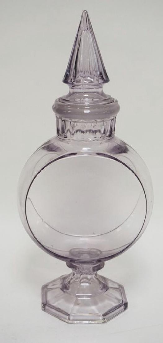 BANJO APOTHECARY JAR IN A LIGHT LAVENDER. ORIGINAL: BANJO APOTHECARY JAR IN A LIGHT LAVENDER. ORIGINAL GROUND FIT LID. 18 1/2 INCHES HIGH.