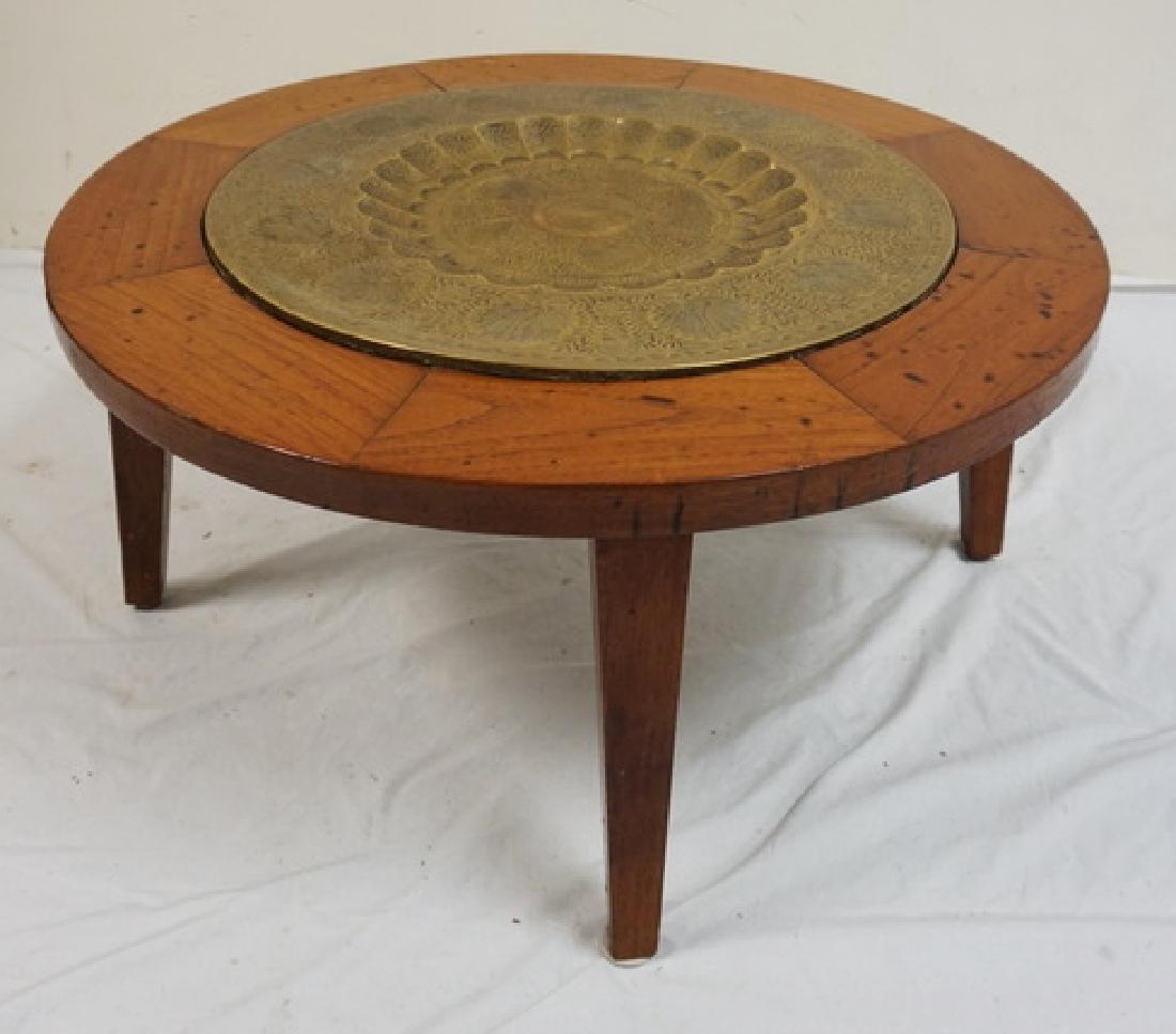 SMALL TABLE WITH AN INSET BRASS TRAY CENTER HAVING HAND: SMALL TABLE WITH AN INSET BRASS TRAY CENTER HAVING HAND CHASED DECORATIONS. 32 INCH DIA. 15 1/2 INCHES HIGH.