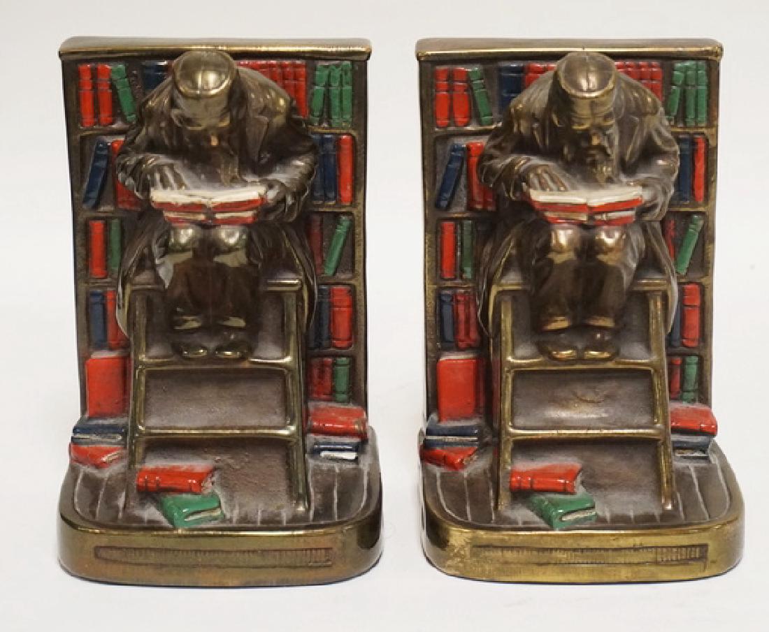 PAIR OF POLYCHROME PAINTED BOOKENDS OF A MAN SEATED ON (1 of 2)