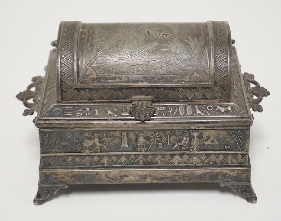 VICTORIAN SILVER PLATED JEWELRY CASKET WITH AN EGYPTIAN: VICTORIAN SILVER PLATED JEWELRY CASKET WITH AN EGYPTIAN MOTIF. DOMICAL LIFT TOP WITH 2 DRAWERS ON THE SIDES. 7 INCHES WIDE. 4 INCHES HIGH.