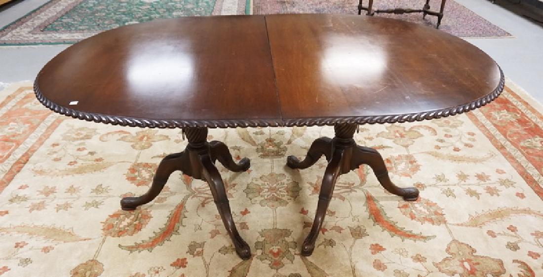 MAHOGANY DINING TABLE BY CHARAK HAVING CARVED DOUBLE: MAHOGANY DINING TABLE BY CHARAK HAVING CARVED DOUBLE PEDESTALS AND A CARVED EDGE. 66 X 44 INCH TOP PLUS TWO 18 INCH LEAVES.