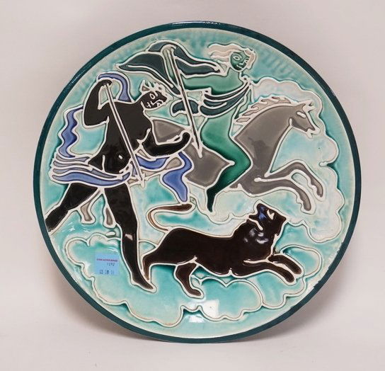 MID CENTURY MODERN POTTERY BOWL WITH RAISED DESIGNS OF: MID CENTURY MODERN POTTERY BOWL WITH RAISED DESIGNS OF HUNTERS ON HORSEBACK AFTER A LION. STAMPED *ENGLAND*. TITLED *BAJO & HAVEZI AND DATED 1950. 15 1/4 INCH DIA. 3 1/4 INCHES HIGH. HAS A SMALL NICK