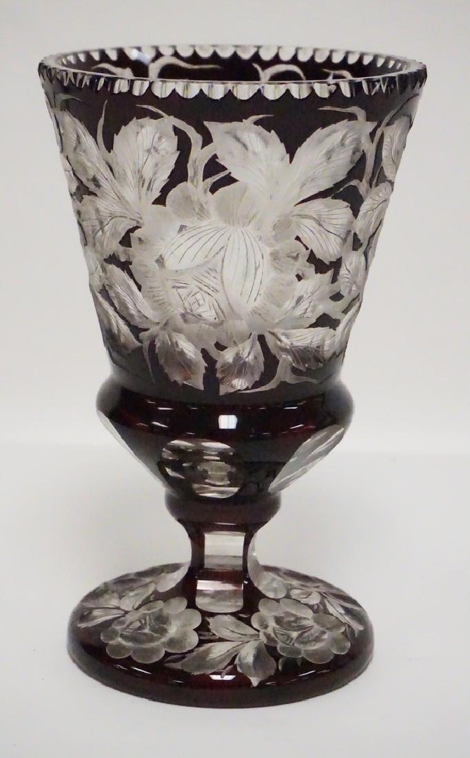 CUT TO CLEAR FOOTED VASE.: BOHEMIAN CUT TO CLEAR VASE WITH DEEP FLORAL CUTTING FROM PIGEAON BLOOD TO CLEAR. 8 1/2 INCHES HIGH.