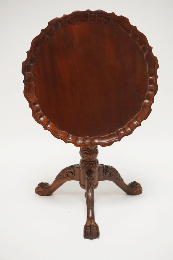 DIMINUTIVE CARVED MAHOGANY TILT TOP TABLE WITH A PIE: DIMINUTIVE CARVED MAHOGANY TILT TOP TABLE WITH A PIE CRUST TOP AND BALL AND CLAW FEET. 14 INCHES HIGH.