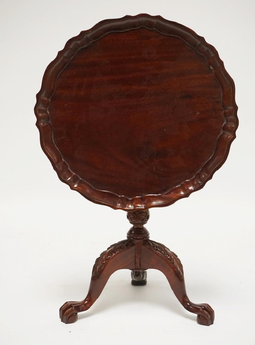 DIMINUTIVE CARVED MAHOGANY TILT TOP TABLE WITH A PIE: DIMINUTIVE CARVED MAHOGANY TILT TOP TABLE WITH A PIE CRUST TOP AND BALL AND CLAW FEET. 13 INCHES HIGH.