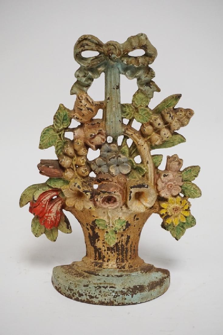 IRON DOORSTOP: ANTIQUE IRON FLOWER BASKET DOORSTOP. 10 1/2 INCHES HIGH.