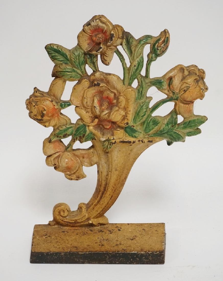 CORNUCOPIA DOORSTOP: ANTIQUE CAST IRON FLOWERING CONRUCOPIA DOORSTOP. 10 INCHES HIGH.