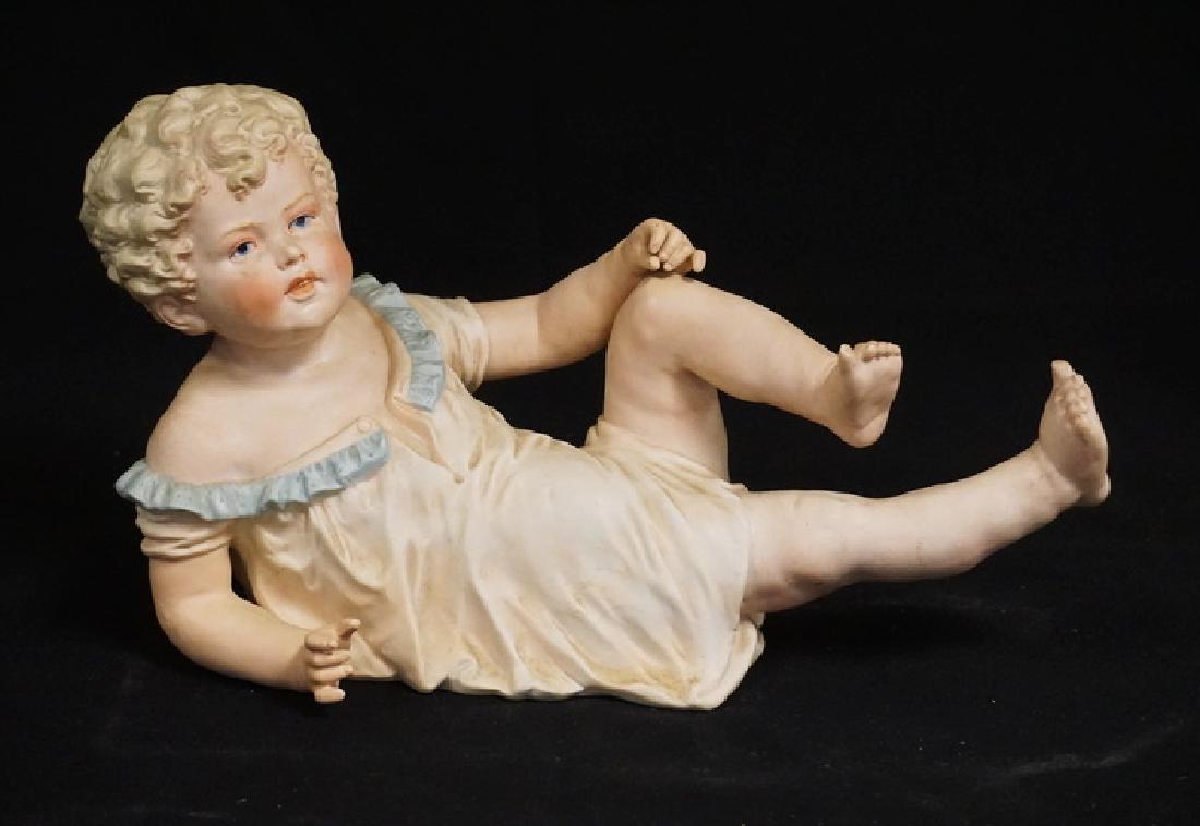 BISQUE PORCELAIN PIANO BABY - RECLINING FIGURE.: BISQUE PORCELAIN PIANO BABY - RECLINING FIGURE. 13 INCHES LONG.
