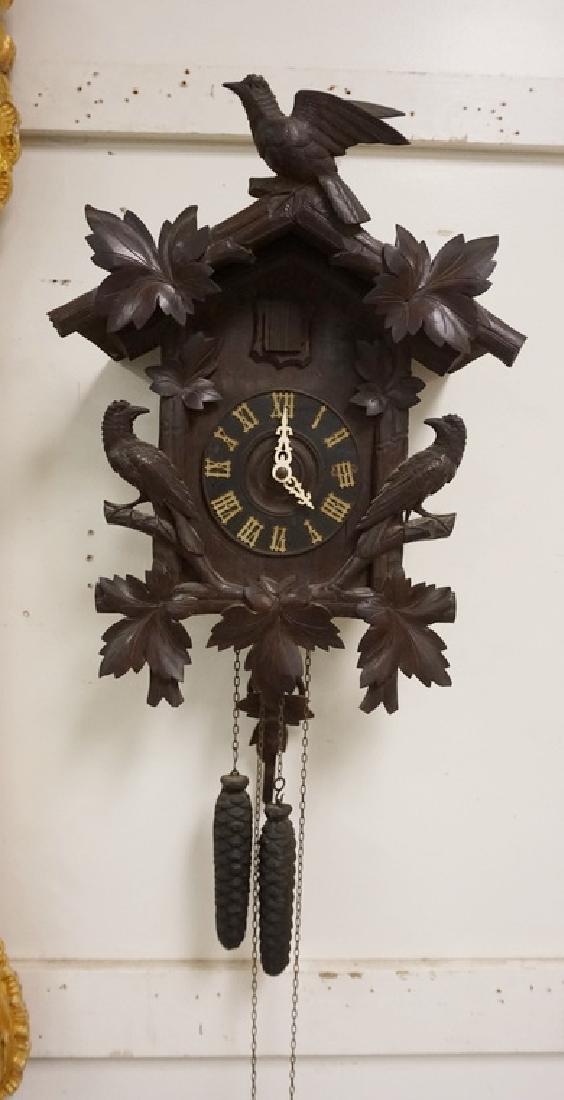 GERMAN WALNUT COCKOO CLOCK: GERMAN CARVED WALNUT COCKOO CLOCK WITH FULL FIGURED BIRDS AND LEAVES. 19 1/4 INCHES HIGH. 14 1/2 INCHES WIDE.