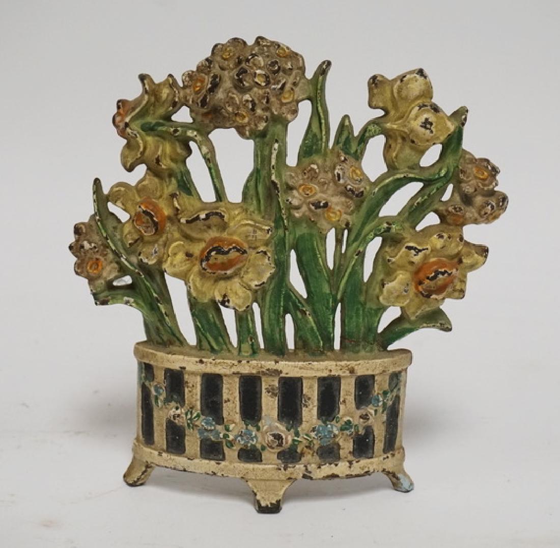 IRON DOORSTOP: ANTIQUE CAST IRON FLOWER FORM DOORSTOP. 7 3/8 INCHES HIGH.