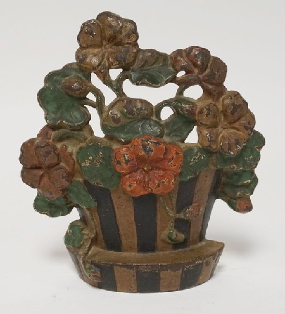 FLOWER DORSTOP: ANTIQUE CAST IRON POTTED FLOWER DOORSTOP. 7 1/8 INCHES HIGH.