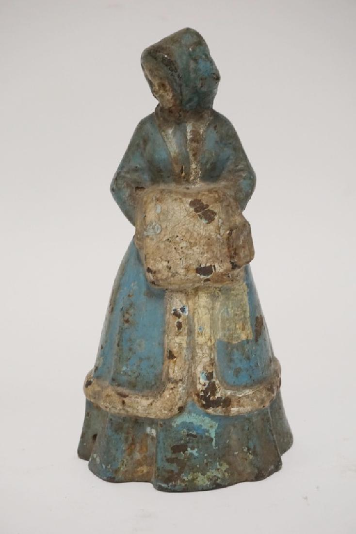 ANTIQUE DOORSTOP: ANTIQUE CAST IRON DOORSTOP IN THE FORM OF A WOMAN IN A BLUE DRESS WITH A MUFF. 9 1/2 INCHES HIGH.