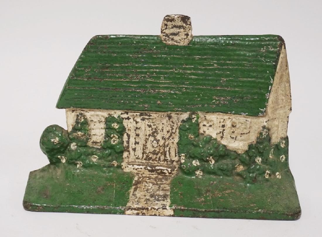 COTTAGE DOORSTOP: CAST IRON COTTAGE DOORSTOP. 5 3/4 INCHES HIGH.