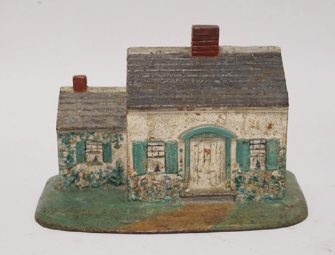 COTTAGE DOORSTOP: CAST IRON COTTAGE DOORSTOP. 4 3/4 INCHES HIGH.