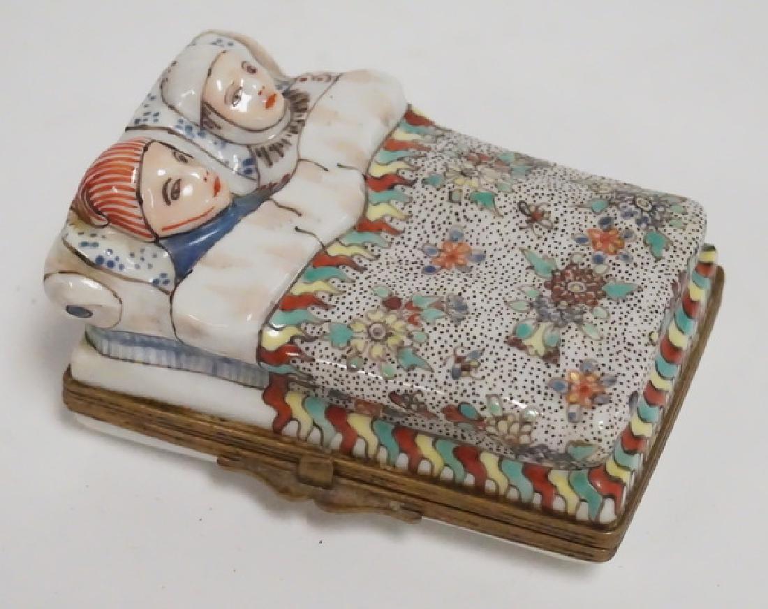 HAND PAINTED PORCELAIN TRINKET BOX.: HAND PAINTED PORCELAIN TRINKET BOX IN THE FORM OF A COUPLE IN BED. 3 1/4 INCHES LONG.