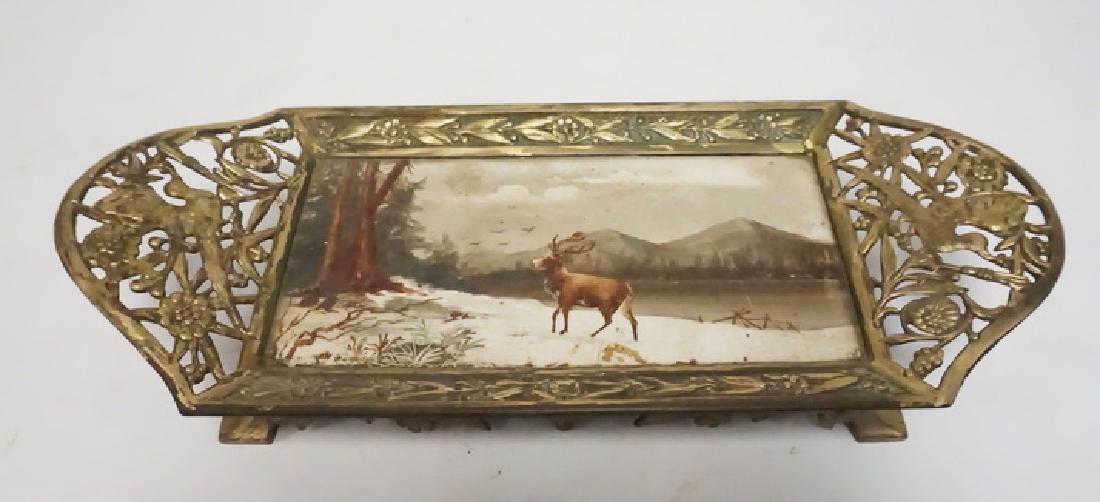 HAND PAINTED TILE WITH AN OPENWORK BRASS FRAME: HAND PAINTED TILE WITH AN ORNATE OPENWORK BRASS FRAME. TILE HA SA CORNER CHIP THAT IS NOT VISIBLE FROM THE TOP. 13 1/2 X 5 3/4 INCHES