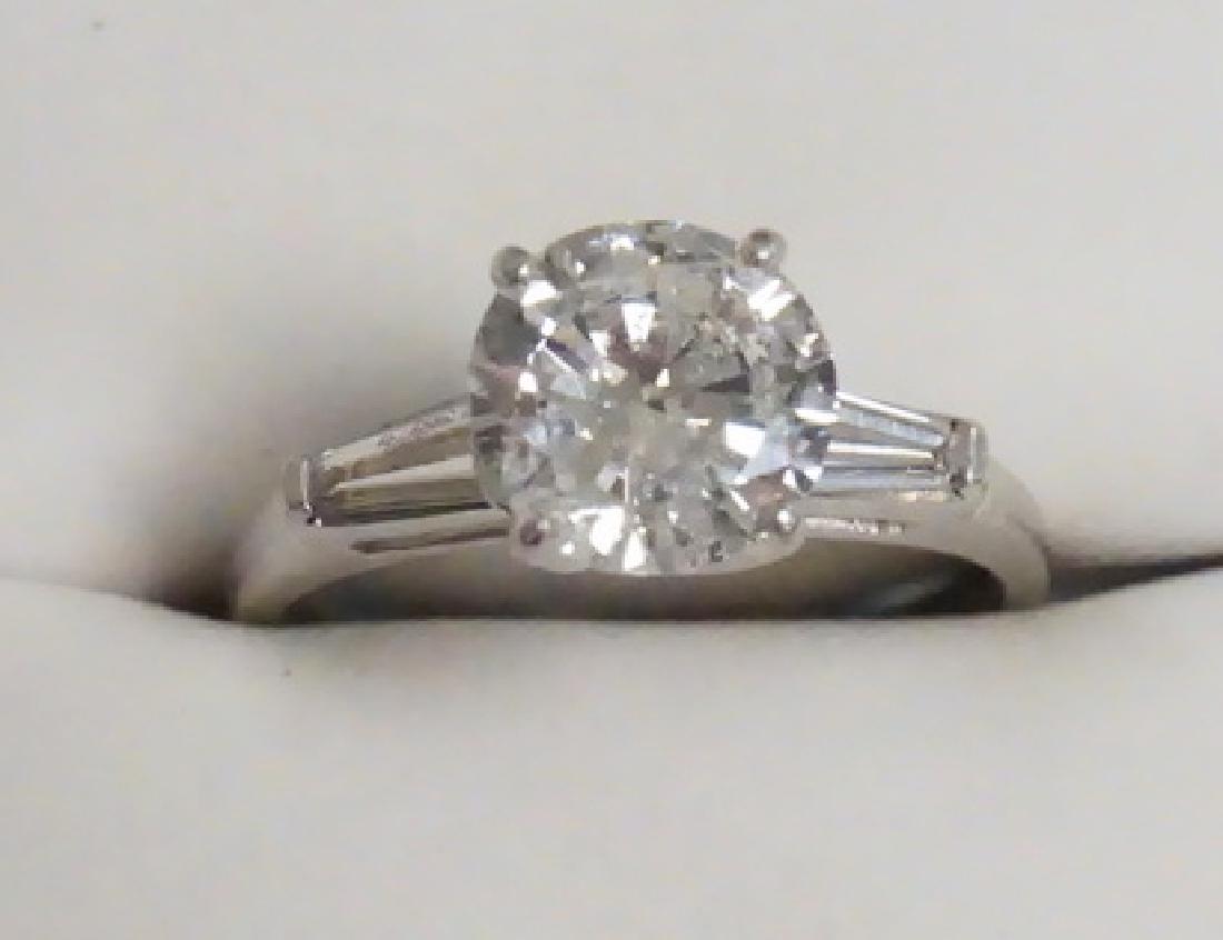 APPROXIMATELY 3 CT DIAMOND PLATINUM RING: DIAMOND ENGAGEMENT RING. APPROXIMATELY 3 CT ROUND DIAMOND FLANKED BY 2 BAGUETTE DIAMONDS. PLATINUM SETTING. APPROX SIZE 9.