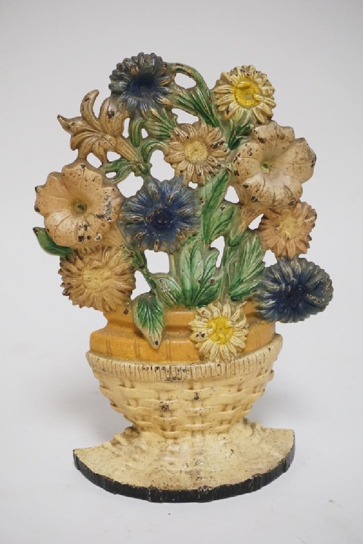 ANTIQUE DOORSTOP: ANTIQUE CAST IRON FLOWER BASKET DOORSTOP. 9 1/4 INCHES HIGH.