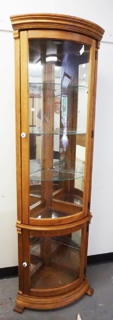 CORNER CURIO CABINET: CORNER CURIO CABINET WITH A MIRRORED BACK, LIGHTED INTERIOR, AND GLASS SHELVES. 76 1/2 INCHES HIGH. 23 3/4 INCHES WIDE.