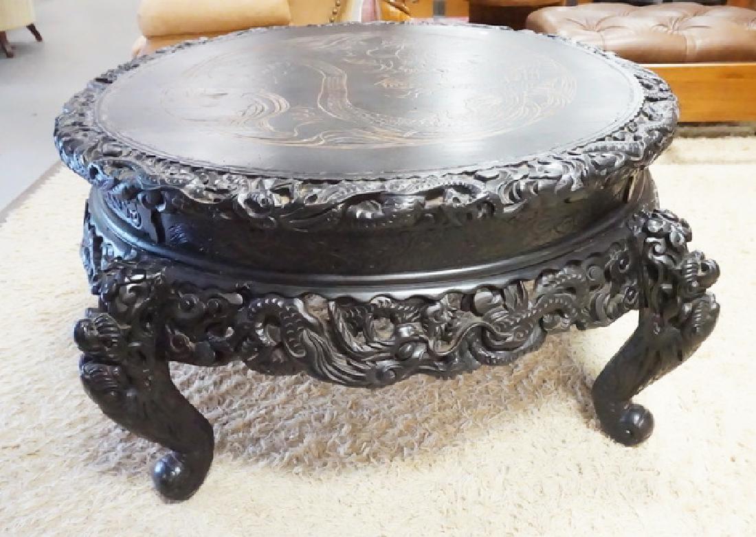 LARGE CARVED ASIAN TABLE.: LARGE CARVED ASIAN TABLE WITH DEEP RELIEF AND OPENWORK CARVINGS. 51 INCH DIA. 26 INCHES HIGH.