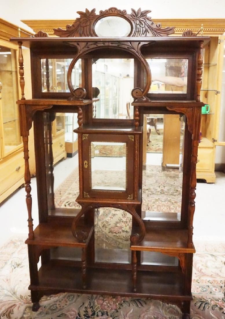 CARVED ETEGERE: CARVED ETEGERE WITH TURNED SUPPORTS AND A BEVELED MIRROR PANELED BACK. 70 INCHES HIGH. 38 INCHES WIDE.
