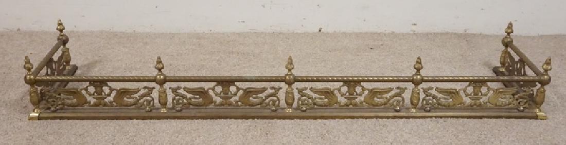 BRASS FIREPLACE FENDER WITH URNS AND SWANS: BRASS FIREPLACE FENDER WITH OPENWORK DECORATION INCLUDING URNS AND SWANS. 54 1/4 INCHES LONG.