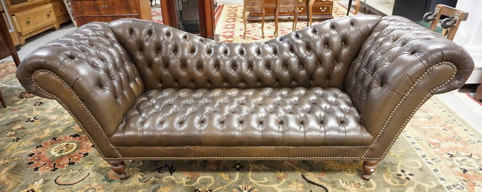BROWN LEATHER SOFA: TUFTED BROWN LEATHER SOFA. 97 INCHES LONG. SOME FADING.