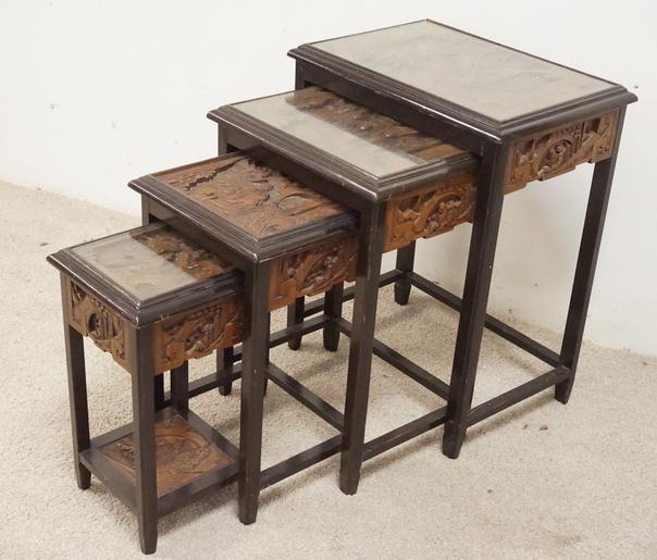 NEST OF 4 CARVED TABLES: NEST OF 4 CARVED TABLES. EACH WITH ASIAN STYLE CARVED SCENES.