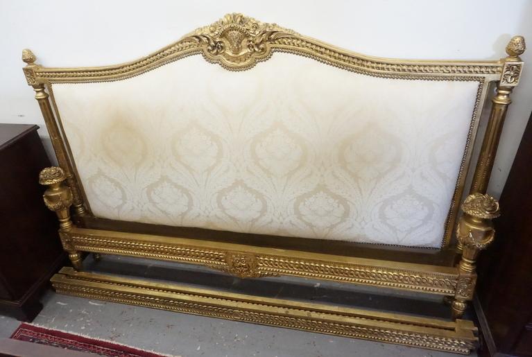 GILTWOOD KING SIZE BED: ORNATE GILTWOOD KING SIZE BED WITH A FABRIC PANELED HEADBOARD. 78 INCHES WIDE. 52 INCHES HIGH.
