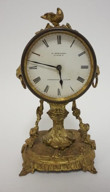 VICTORIAN GUILT METAL DRESSER CLOCK: VICTORIAN GUILT METAL DRESSER CLOCK, FACE IS MARKED H ROBINSON 15 HIGH STREET SHREWSBURY & LUDOW, CASE HAS LIONS HEAD & A BIRD AT THE TOP, 9 1/4 IN H