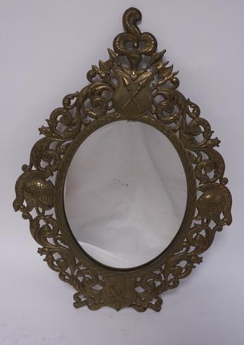 CAST IRON MIRROR: ORNATE CAST IRON MIRROR WITH MEDIEVAL MILITARY HARDWARE SMALL CHIP AT THE TOP OF THE GLASS. 17 1/2 IN X 12 1/2 IN