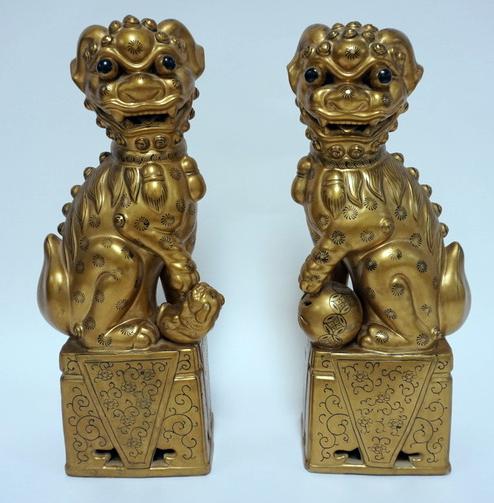 PR OF GILT CERAMIC FOO DOGS: PR OF GILT CERAMIC FOO DOGS WITH BLACK PAINTED DECORATION. ONE HAS A REPAIR. 14 3/4 IN H
