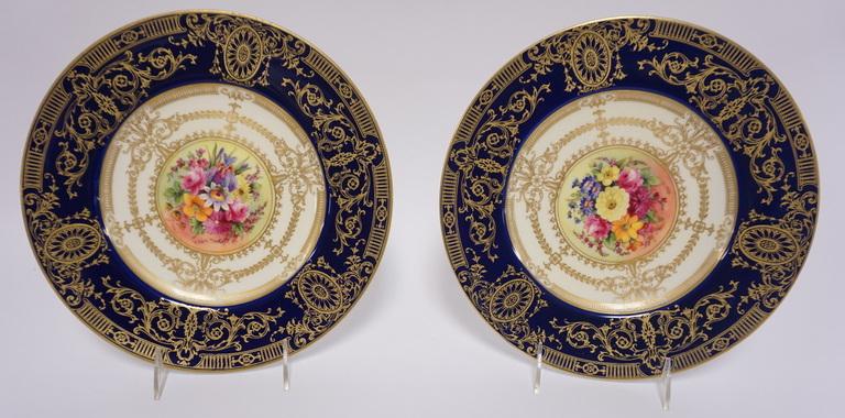 PR OF ROYAL WORCESTER SERVICE PLATES: PAIR OF ROYAL WORCESTER SERVICE PLATES WITH ELABORATE COBALT BLUE AND GOLD BORDERS AND COLORFUL FLORAL CENTERS. 10 1/2 IN