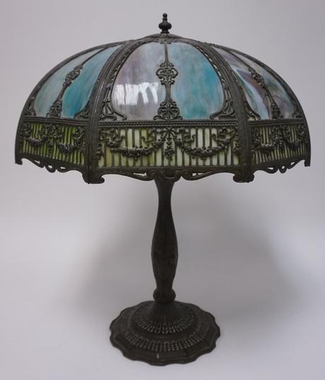 ANTIQUE SLAG GLASS LAMP: ANTIQUE BLUE SLAG GLASS LAMP W/ ORNATE METAL OVERLAY, DAMAGE TO SHADE, ONE PANEL IS MISSING, 25 IN H