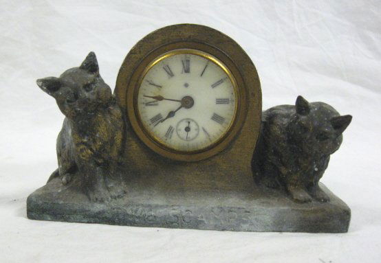 METAL CLOCK W/2 CATS *TWO SCAMPS*; 4 IN H, 6 1/2: METAL CLOCK W/2 CATS *TWO SCAMPS*; 4 IN H, 6 1/2 IN W; ALL CLOCKS SOLD AS IS/AS FOUND. WORKING CONDITION IS UNKNOWN, POSSIBLY MISSING PENDULUM, WEIGHTS, PIECES, PARTS AND/OR KEYS