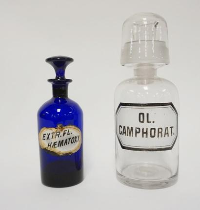 2 ANTIQUE APOTHECARY BOTTLES: 2 ANTIQUE APOTHECARY BOTTLES, ONE IS COLORED BLUE, STOPPER STUCK, 5 3/4 IN HIGH, CLEAR BOTTLE HAS A TUMBLER TOP & A LIPPED POURING STOPPER, 7 3/4 IN HIGH