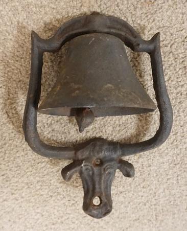 SMALL CAST IRON BELL WITH COWS HEAD: SMALL CAST IRON BELL WITH COWS HEAD, 12 IN HIGH, OPEN END OF BELL 6 IN, WIDEST POINT OF FRAME 8 1/2 IN